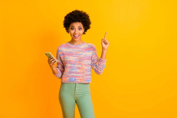 クレイジーファンキーなアフリカ系アメリカ人の女の子のポートレート使用スマートフォンのタイプのポストの考え感銘を受けた信じられないほどのアイデア悲鳴すごいオムグアップ指を着用緑のズボン孤立明るい色の背景 — ストック写真