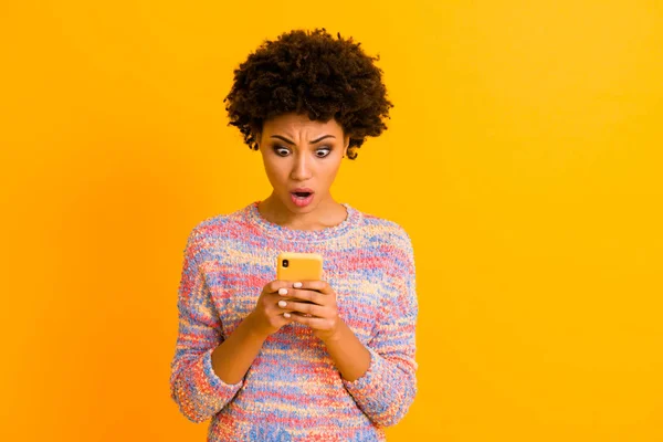 Retrato de loca chica afroamericana impresionada uso de teléfono celular leer increíbles bloggers información de la red social mirar fijamente gritar wow omg desgaste elegante traje aislado brillo color fondo — Foto de Stock