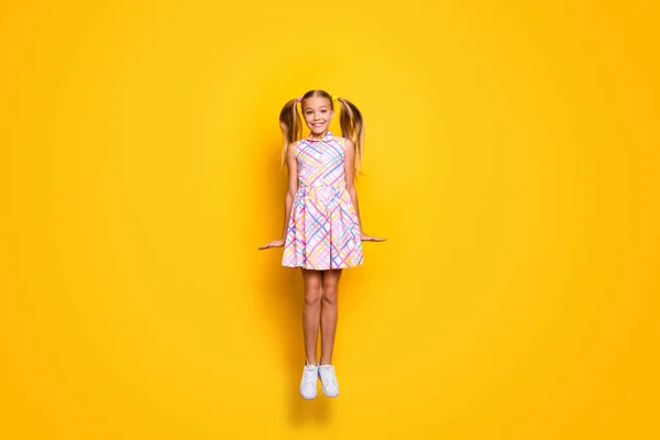 Full body photo of content dreamy schoolkid jump enjoy rest relax spring weekend holiday wear trendy checkered skirt isolated over shine color background — 스톡 사진