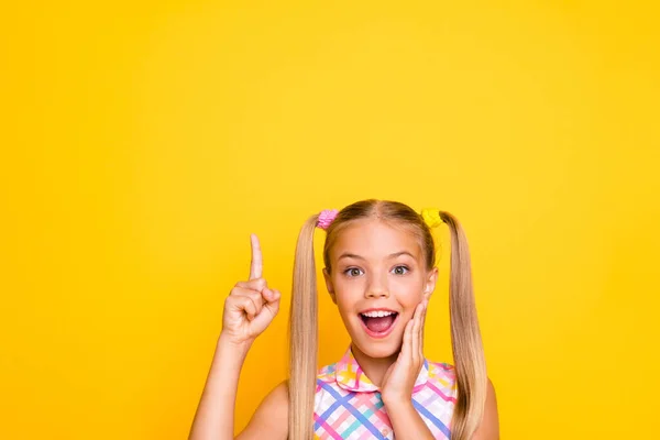 Foto de primer plano de alegre dama de buen humor dedo directo hasta vacío espacio venta precios mano en la mejilla desgaste vestido de verano a cuadros aislado amarillo brillo color fondo —  Fotos de Stock