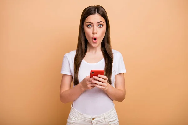 Portrait of astonished girl use cellphone read social network information impressed scream unbelievable unexpected wear good look outfit isolated over beige color background — Stock Fotó