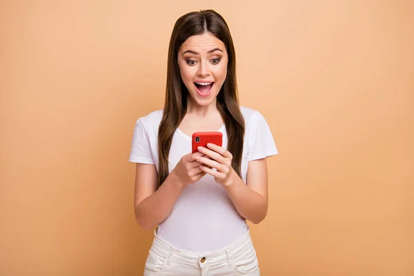 Portrait of astonished funky modern girl use cellphone read social media information impressed scream wow omg wear good look outfit isolated over beige color background — Stock fotografie