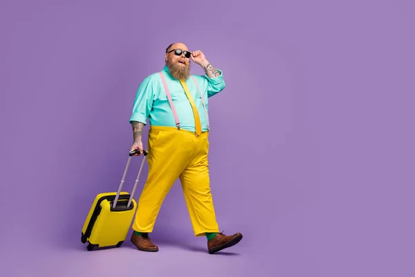 Full length body size view of cheerful confident guy carrying bag touching specs low cost airline exotic destination abroad isolated on bright vivid shine vibrant violet purple lilac color background — Zdjęcie stockowe