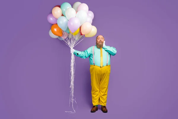 Full length photo excited astonished man big belly hold air baloons he get anniversary gift present scream wow wear turquoise trousers shoes pink suspenders isolated purple color background — Stok fotoğraf