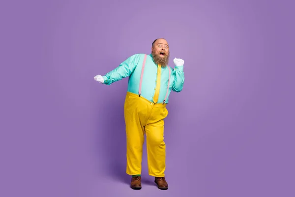 Full body photo of positive cheerful fat man enjoy dancing on discotheque wear turquoise shirt trousers white gloves isolated over vivid color background — Stock fotografie