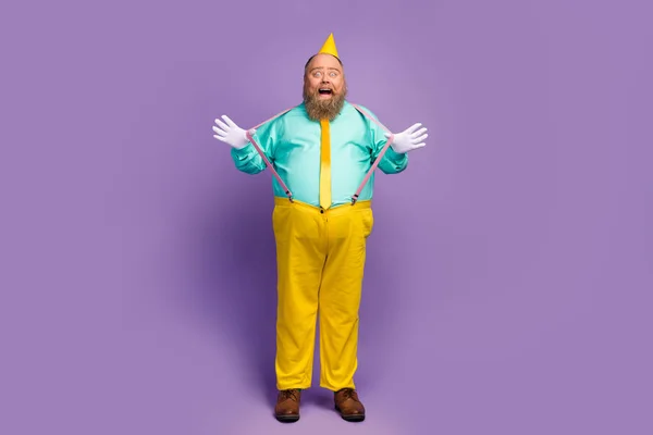 Full length photo of positive cheerful fat man enjoy anniversary celebration pull pink stylish suspenders wear trousers teal footwear isolated over shine purple color background — Stok fotoğraf