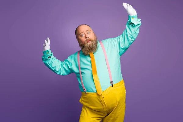 Portrait of fun cool crazy funky fat overweight man enjoy event party dancing raise fists feel carefree careless wear turquoise clothes isolated over purple shine color background — Stock fotografie