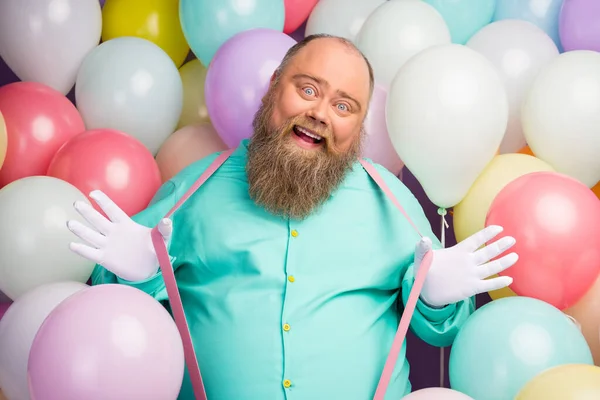 Ritratto di spensierato uomo giocoso divertente funky hipster godere di anniversario festa celebrazione tirare rosa bretelle indossare camicia verde acqua sopra aria baloons sfondo — Foto Stock