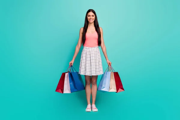 Full size photo of cheerful pretty girl enjoy shopping buy hold many bags wear tank-top shoes isolated over pastel turquoise color background — Stockfoto