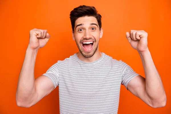 Goal. Photo of crazy funky energetic guy open mouth best feelings watch football match game raise fists wear casual striped t-shirt isolated bright orange color background — ストック写真