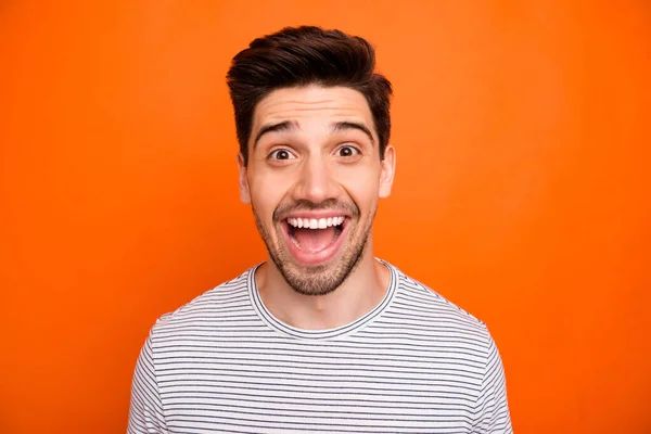 Closeup photo of crazy funky energetic guy open mouth best excited feelings emotions listen good news wear casual striped t-shirt isolated bright orange color background — 스톡 사진