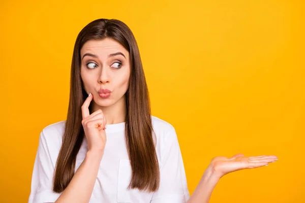 Photo of pretty business lady hold novelty selling product on open palm looking side empty space interested amazing offer wear casual white t-shirt isolated vivid yellow color background — Φωτογραφία Αρχείου