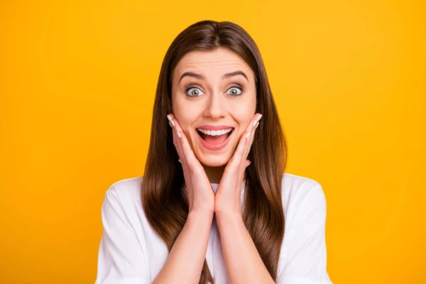 Closeup photo of funky pretty lady listen amazing news open mouth arms on cheeks screaming delighted wear casual white t-shirt isolated vibrant yellow color background — Stockfoto