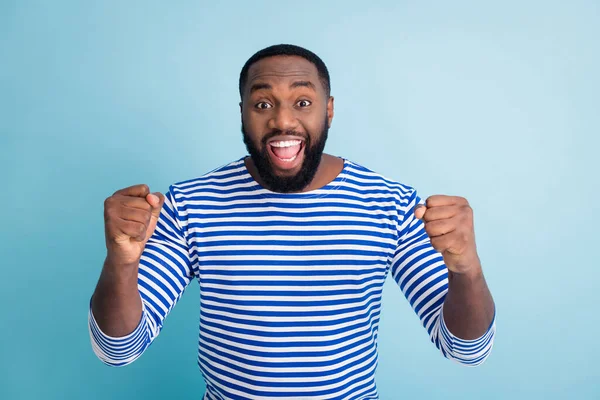 Portrait of ecstatic cheerful afro american guy celebrate spring time holiday lottery win raise fists scream yeah wear trendy stylish sailor clothes isolated over blue color background — Stock Fotó