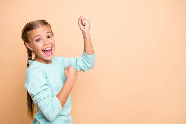 Yeah. Profile photo of beautiful excited little lady ambitious raise fist celebrate success astonished ecstatic wear blue pullover isolated beige pastel color background — Stockfoto