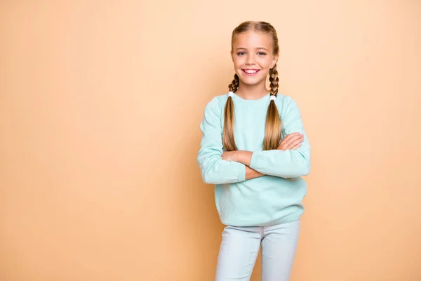 Foto de belo muito pequeno senhora braços cruzados melhor aluno do ano auto-confiante menina da escola desgaste azul pulôver jeans isolado bege pastel cor fundo — Fotografia de Stock