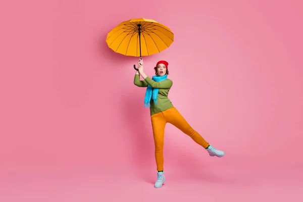 Omg parasol volar lejos. Foto de tamaño completo de chica sorprendida tratar de coger su paraguas brillante sentir miedo mirada mirada estupor desgaste pantalones rojo zapatos de la cabeza jersey aislado sobre fondo de color rosa —  Fotos de Stock