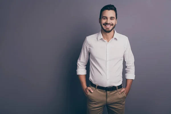 Фото молодого мачо бізнесмена роботодавця інвестора корпоративного семінару дружні усміхнені руки в кишенях носять білі офісні сорочки штани ізольовані сірого кольору — стокове фото