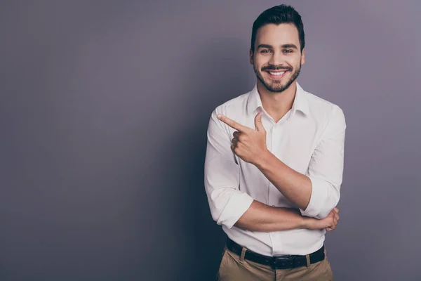 Photo of young handsome business man friendly smiling indicating finger empty space advising novelty product wear white office shirt pants isolated grey color background — Stock Photo, Image