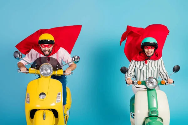 Photo of cool lady guy drive ride two retro moped wear red cape mask protective hats rushing road halloween party play super heroes role coat flying air isolated blue color background — Zdjęcie stockowe