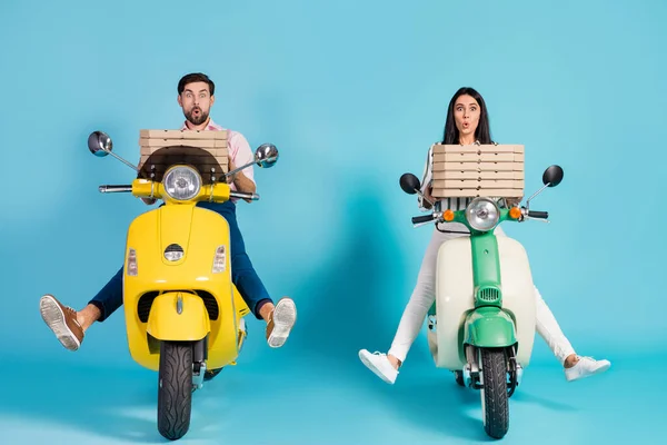 Freins défaillants. pleine longueur photo de fou bouche ouverte dame gars conduire deux vintage cyclomoteur tenir de nombreuses boîtes à pizza en papier profession de messagerie isolé fond de couleur bleue — Photo