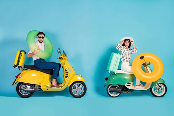 Profil complet du corps photo latérale de surpris deux personnes pilotes Voyage vacances d'été mer côte moto porter anneau caoutchouc vie bouée sacs bagages impressionné isolé fond de couleur bleue — Photo