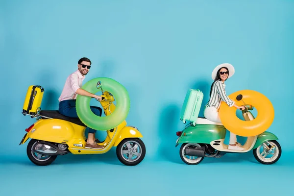 Full size profile side photo positive two people bikers rider driver drive motor bike way to summer sea adventure holiday resort hold life buoy luggage isolated blue color background — Stock Photo, Image