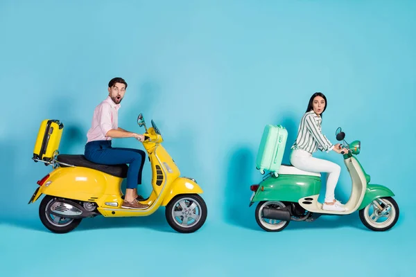 Full body profile photo of shocked lady guy drive two retro moped rush hour rolling suitcases fixed behind addicted travelers formalwear clothes isolated blue color background — Zdjęcie stockowe