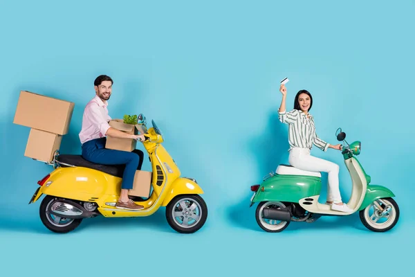 Full size profile side photo positive two people rider driver drive yellow green motor bike buy purchases transport boxes pay credit card wear formalwear outfit isolated blue color background