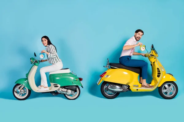 Full body profile side photo funny funky wife husband couple drive motor bike enjoy fast speed route adventure check time on clock bell wear shirt trousers isolated blue color background — Stock fotografie