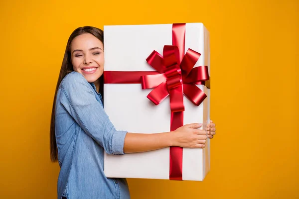Güzel, güzel, neşeli bir kızın portresi 14 Şubat 'ta kutlanan hediye kutusuna sarıldı. Parlak renkli arka planda izole edilmiş güzel bir kıyafet giydi. — Stok fotoğraf