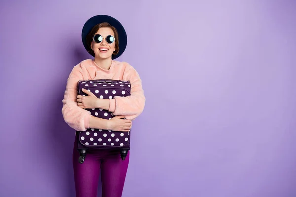 Photo of funny lady vacation waiting registration flight hold hands cute dotted bag wear hat napszemüveg alkalmi trendi rózsaszín pulóver nadrág elszigetelt lila szín háttér — Stock Fotó