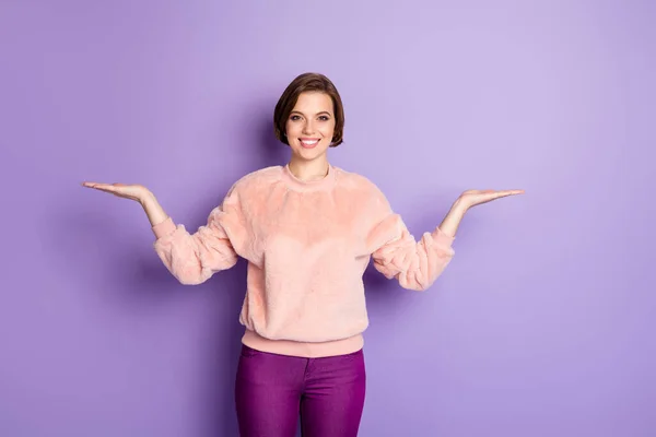 Portrait of cheerful positive girl hold hand present promotion object adverts try pick tips sales discounts wear casual style outfit isolated over purple color background — 스톡 사진