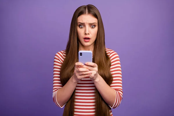 Photo of attractive terrified lady look open mouth telephone screen read negative comments blog post frightened wear casual striped shirt isolated pastel purple color background — Zdjęcie stockowe