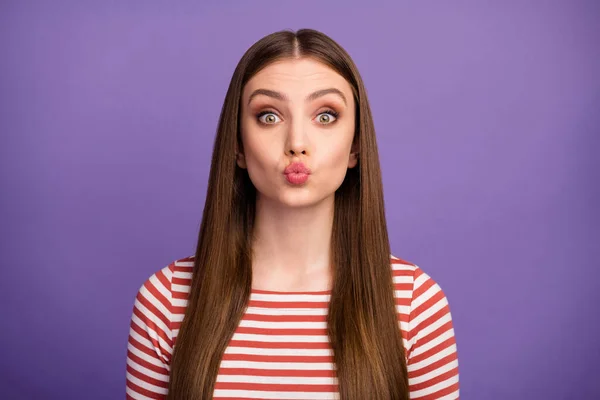 Closeup photo of attractive student lady long hairdo sending air kisses funny facial expression flirty mood wear casual striped shirt isolated pastel purple color background — 스톡 사진
