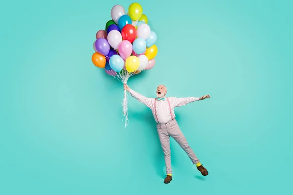 Full length photo amazed excited pensioner man hold many helium balloons flying wind sky he impressed scream wow omg wear pink grey pants trousers brown shoes isolated teal color background — Stockfoto