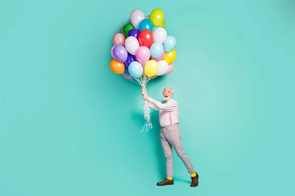 Full body photo funky energetic crazy old white grey bearded man hold many balloons fly wind sky enjoy anniversary festive celebration wear pink outfit shoes isolated teal color background — Stockfoto