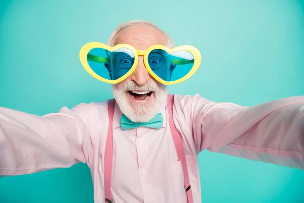 Primer plano foto de emocionado positivo jubilado viejo hombre fin de semana blogger han viaje hacer selfie desgaste rosa traje gafas aislado sobre color turquesa fondo — Foto de Stock