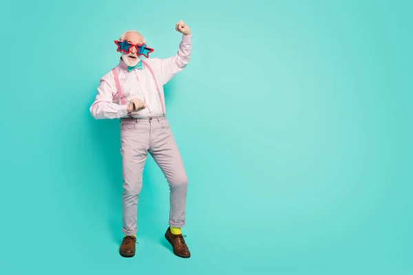Full size photo of funky funny crazy energetic old man clubber dance retro style event clubbing wear bright shine spectacles pink shirt grey pants footwear isolated teal color background — Stockfoto