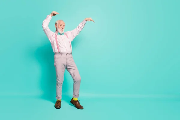 Foto de cuerpo completo de loco anciano retirado baile vintage concierto evento levantar las manos usar camisa rosa pantalones grises zapatos aislados sobre fondo de color turquesa —  Fotos de Stock