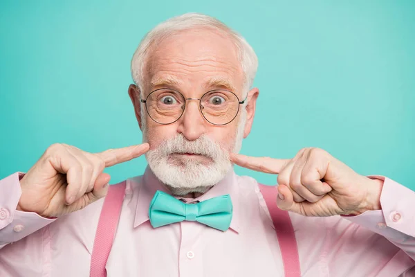 Closeup photo of crazy funky grandpa press fingers on cheeks big eyes no emotions wear specs pink shirt suspenders bow tie isolated bright teal color background — Stock fotografie