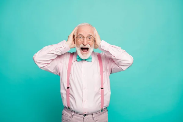 Photo of amazed grandpa positive facial expression arms on head good mood sale shopping advert wear specs pink shirt suspenders bow tie pants isolated bright teal color background — Stockfoto