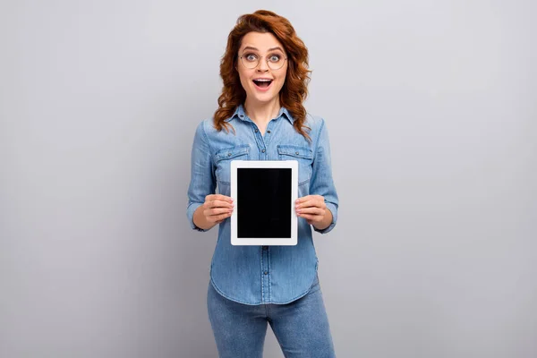 Portrait of astonished ginger hair woman hold tablet demonstrate incredible new modern technology ads promo impressed scream wow omg wear good look clothes isolated grey color background — Stock Photo, Image