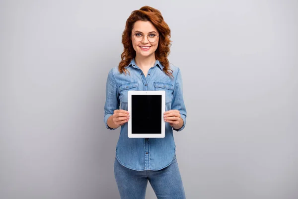 Portrait of positive woman promoter hold tablet present new device ads promo suggest select wear good look clothes isolated over grey color background — Stock Photo, Image