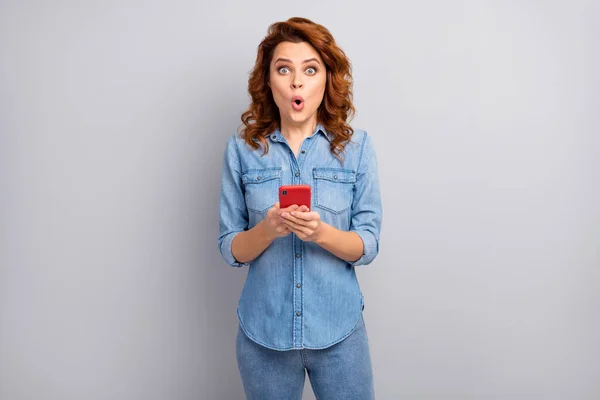 Portrait of astonished crazy woman use cellphone read social media unbelievable novelty impressed scream wow omg wear modern clothes isolated over grey color background — ストック写真