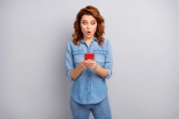 Portrait of astonished woman use smartphone read social network novelty impressed scream unbelievable unexpected wear good look outfit isolated over grey color background — Stockfoto