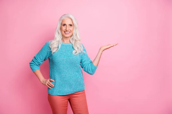 Портрет позитивної веселої старої жінки тримає руку вирішувати поради вибрати рекламу одяг гарний вигляд пуловер ізольований на пастельному кольоровому фоні — стокове фото