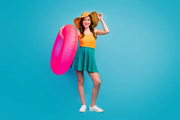 Full length photo of pretty funny lady traveler good mood exotic resort hold big pink lifebuoy swimming ocean sea time wear mini summer dress hat shoes isolated blue background — Stockfoto