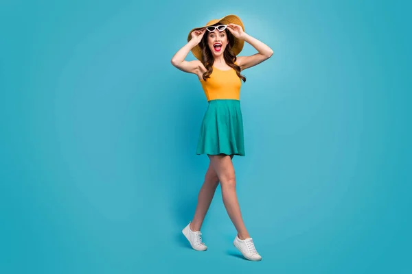 Fuil size photo astonished girl walk go free time look unbelievable ads impressed scream touch hands specs wear sneakers shine short mini tank-top isolated blue color background — Stockfoto