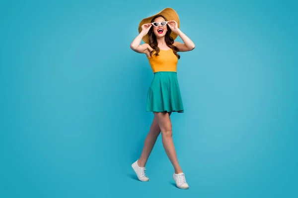 Full length photo candid cute sweet girl enjoy spring free time vacation look incredible excursion sights touch hands spectacles wear bright singlet sunhat shoes isolated blue color background — Stockfoto